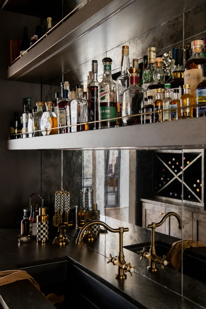 Bar remodel in McGavock Farms, Brentwood. Dark White Oak Rift Sawn cabinetry, antique mirror tile, open shelving, and brass fixtures by Sebring Design Build.