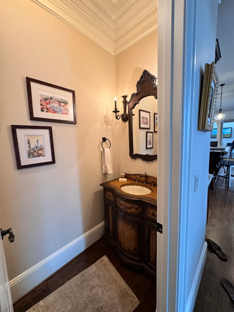 Powder room remodel in McGavock Farms, Brentwood. Cambria Remington Brass countertop, custom floating vanity, Delta Luxe Gold fixtures, and rich wall paneling by Sebring Design Build.