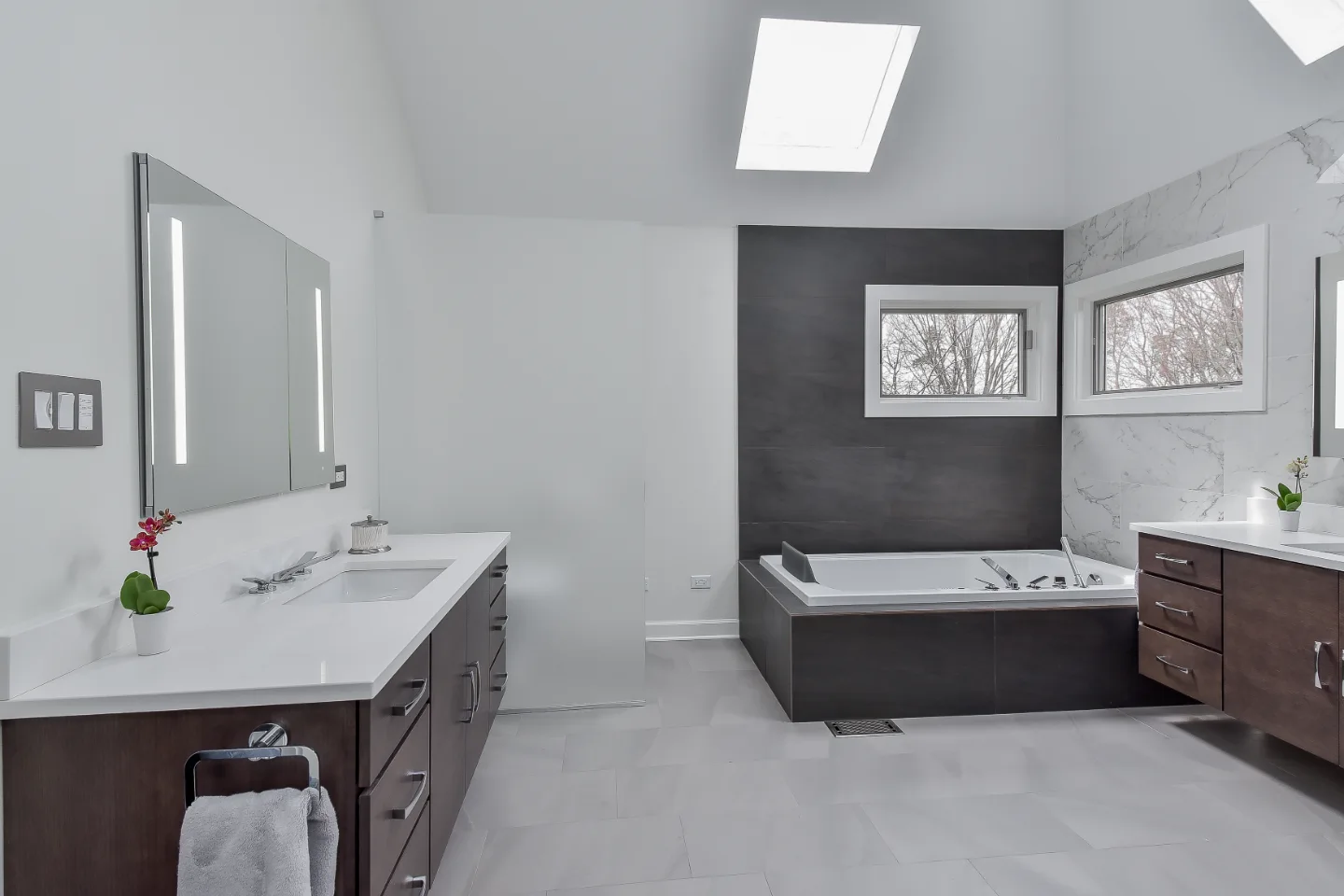 A modern-crisp primary bath remodel in Brentwood, Tennessee. Wellborn Barcelona Oak Drift cabinetry, Orion Absolute White quartz, Atlas Concorde Calacatta Extra tile, and Polished Chrome fixtures by Sebring Design Build.