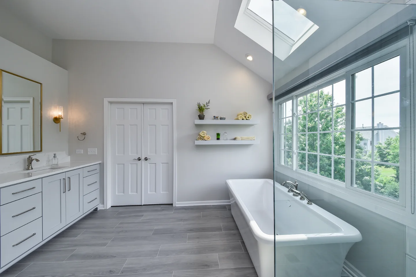 A modern-unique primary bath remodel in Brentwood, Tennessee. Pearl cabinetry, Hanstone Tranquility quartz, MTI Rectangle soaking tub, and Lunada Bay iridescent accent tile by Sebring Design Build.