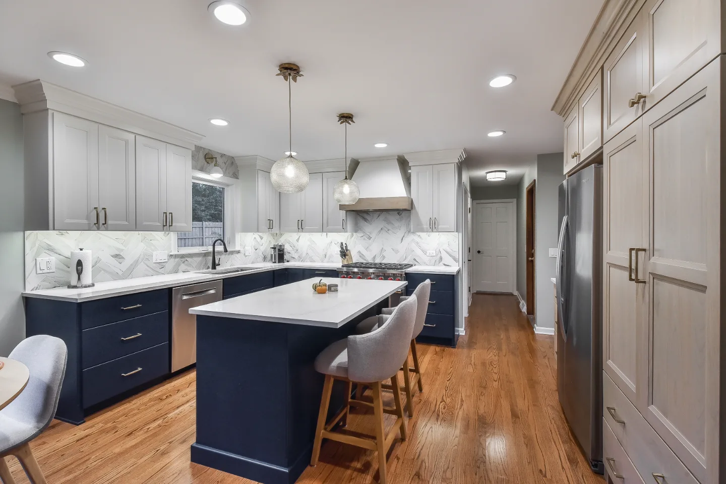 A modern-coastal kitchen remodel in Brentwood, Tennessee. Two-tone cabinetry, Caesarstone Calacatta Nuvo, and Matte Black fixtures by Sebring Design Build.