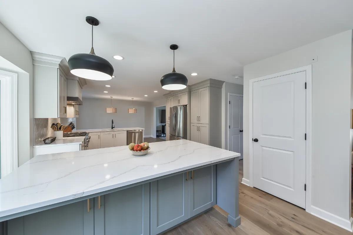 A modern-clean kitchen remodel in Franklin, TN. Soft white perimeter cabinetry, warm dune uppers, and a Puget Sound blue island by Sebring Design Build.