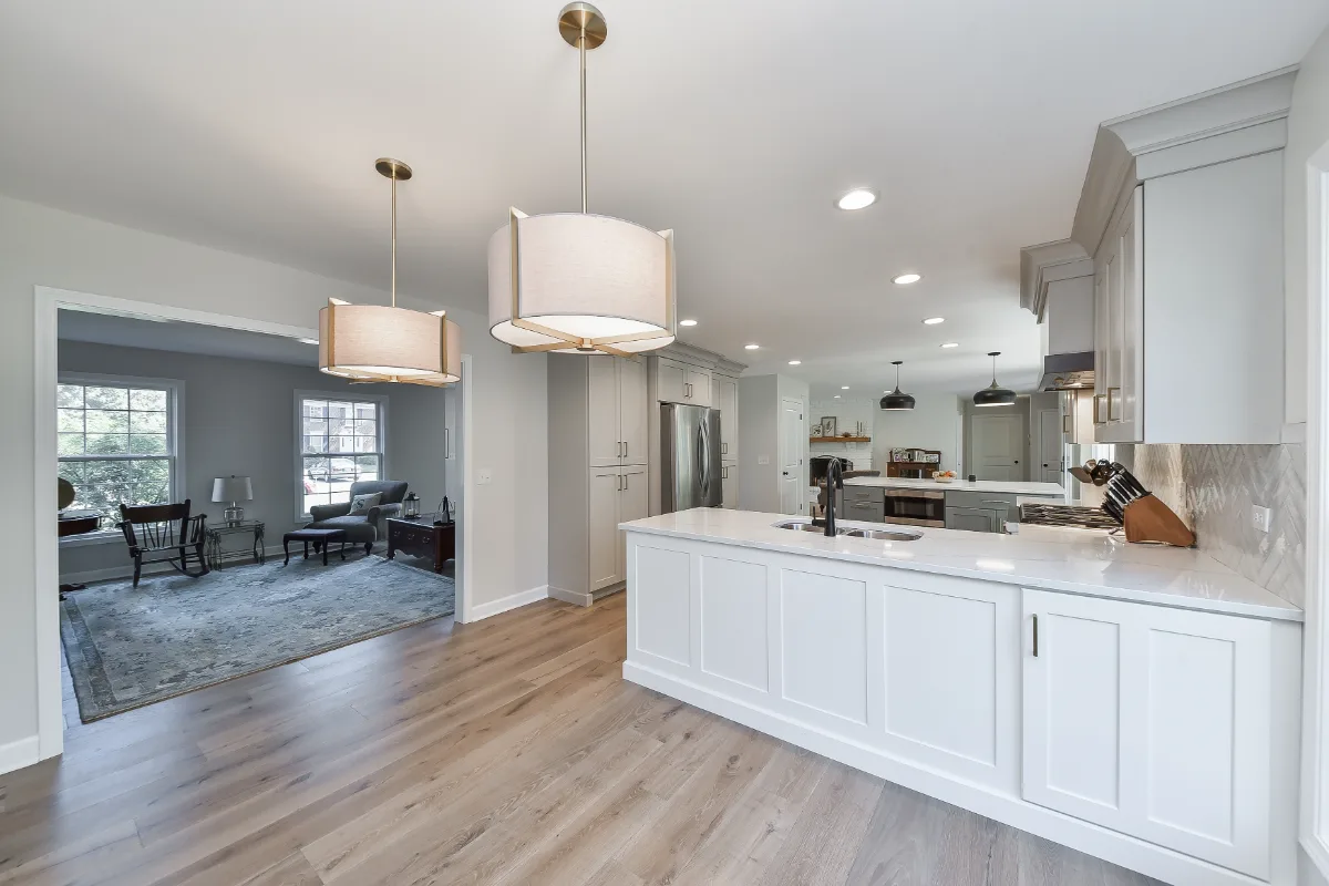 A modern-clean kitchen remodel in Franklin, TN. Soft white perimeter cabinetry, warm dune uppers, and a Puget Sound blue island by Sebring Design Build.