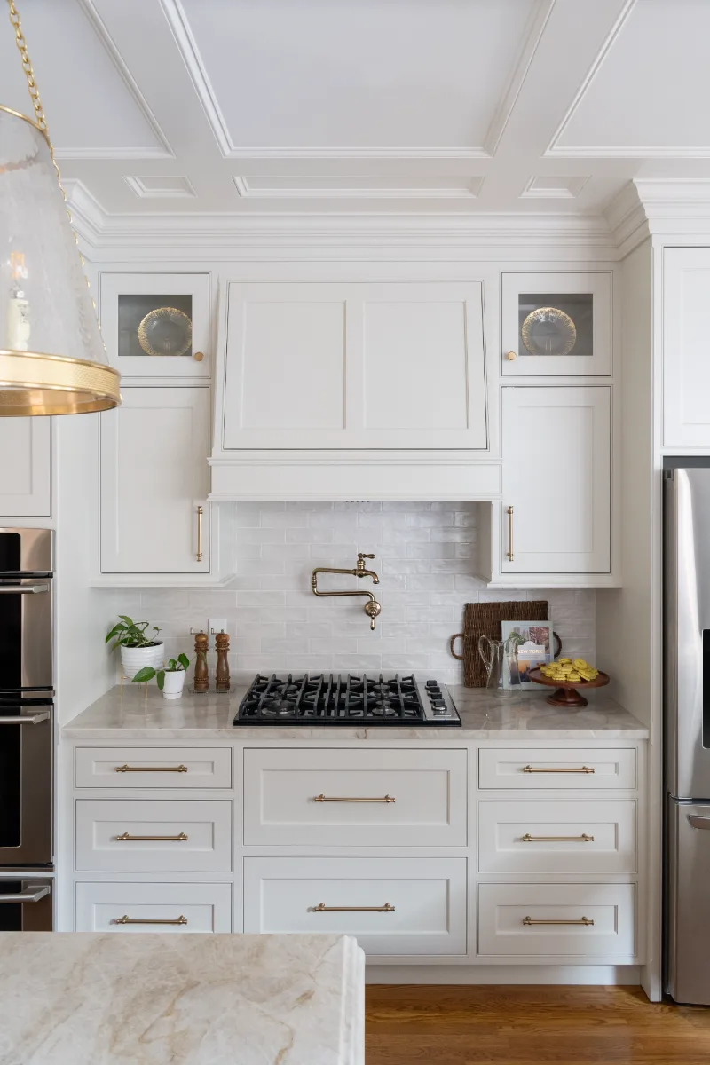 A transitional-elegant kitchen remodel in Cool Springs, Franklin, TN. Soft white cabinetry, a custom wood island, and Taj Mahal quartz by Sebring Design Build.