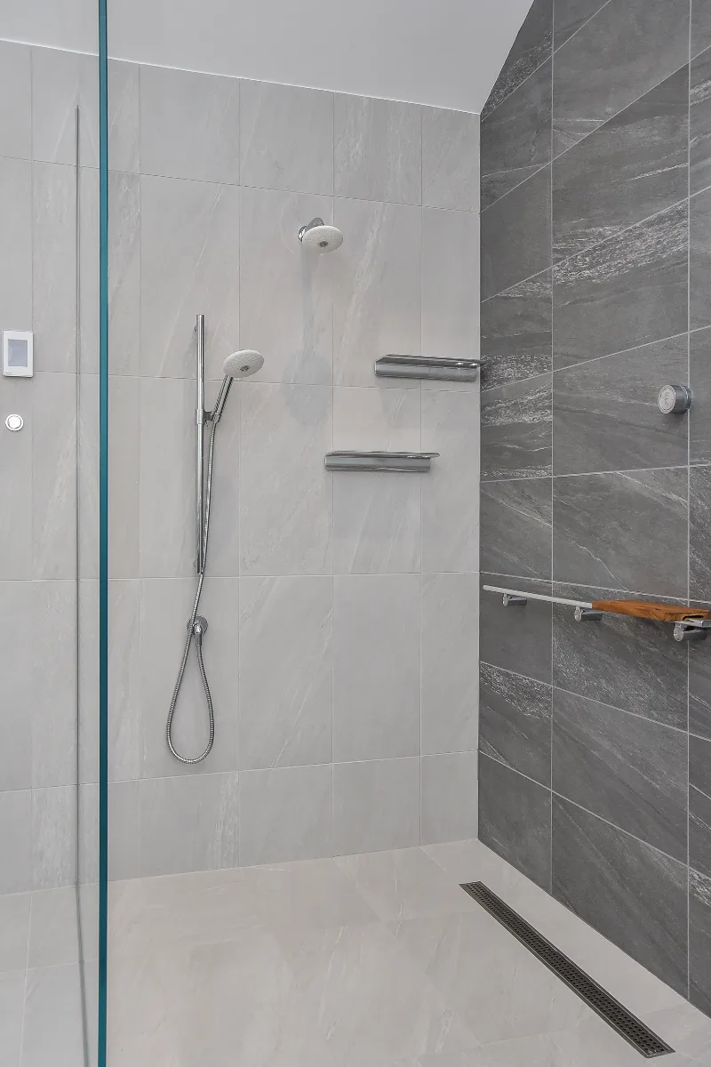 Primary Bath remodel in Franklin, TN. Sebring Design Build transformed this Franklin, Tennessee primary bath with CWP Full Overlay Walnut Ginger Slab cabinetry, CaesarStone Primordia quartz, Delta Pivotal Polished Chrome faucet.