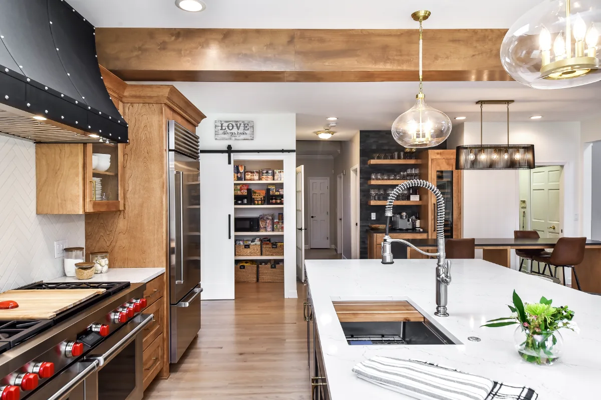 A modern-rustic kitchen, pantry, bar, and dining remodel in Brentwood, TN. CWP Bunker Hill Black and Fruitwood cabinetry with Cambria Charlestown and Colton quartz by Sebring Design Build.
