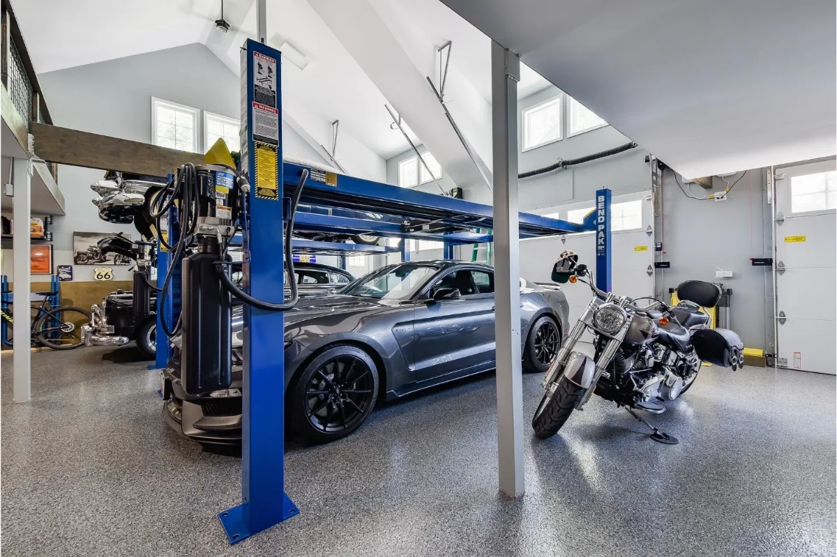 A rustic-organic custom garage and loft remodel in Franklin, TN with creative car lift systems and a tinkering area by Sebring Design Build.