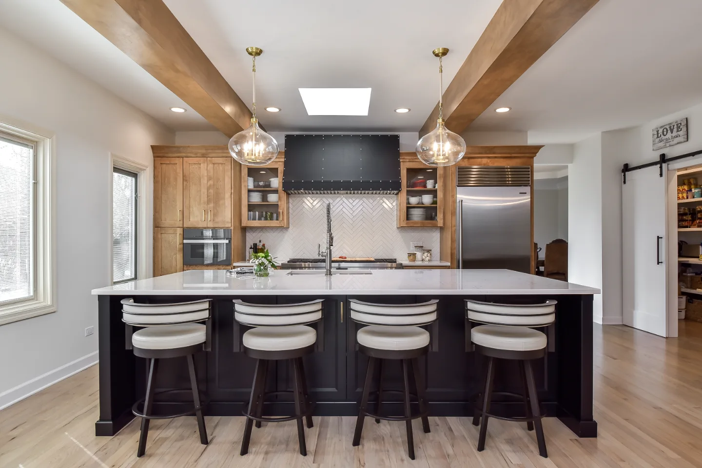 A modern-rustic kitchen, pantry, bar, and dining remodel in Brentwood, TN. CWP Bunker Hill Black and Fruitwood cabinetry with Cambria Charlestown and Colton quartz by Sebring Design Build.