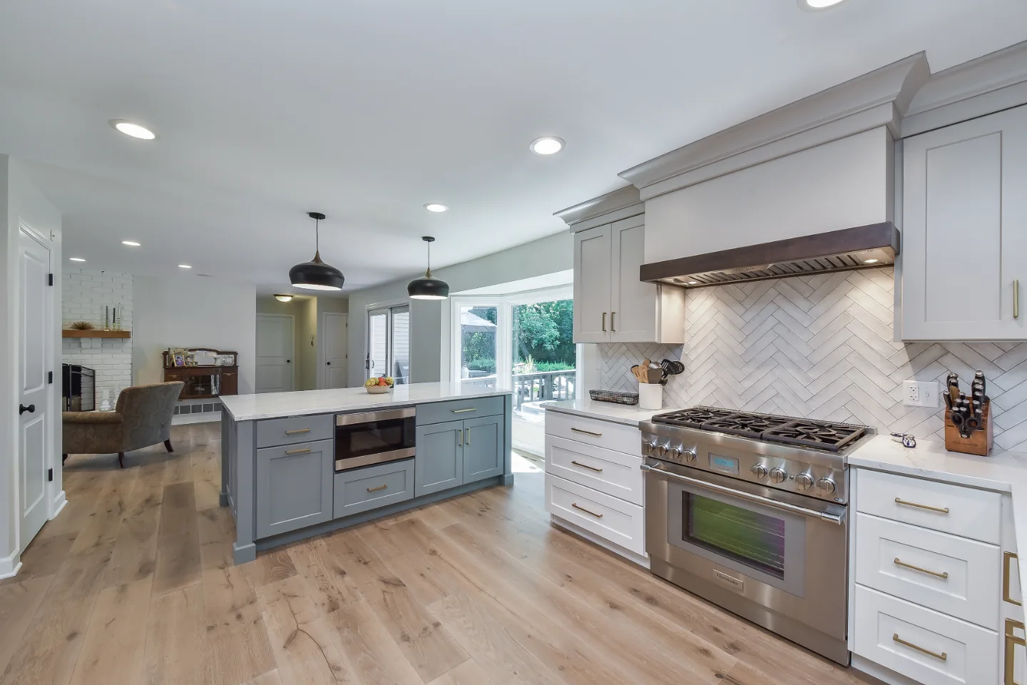 A modern-clean kitchen remodel in Franklin, TN. Soft white perimeter cabinetry, warm dune uppers, and a Puget Sound blue island by Sebring Design Build.