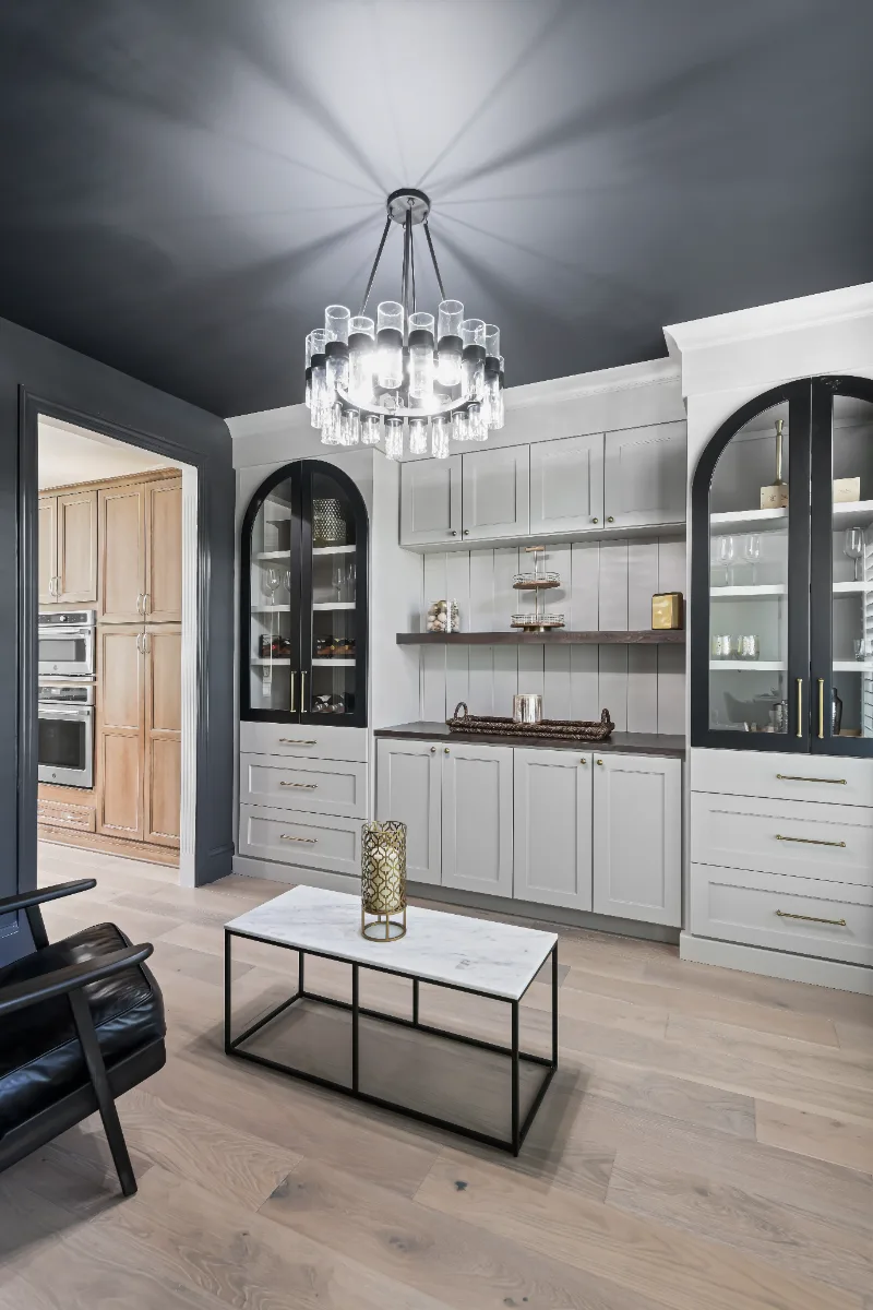 Lounge remodel in Watkins Creek, TN. Sebring Design Build transformed this Watkins Creek dining room in Franklin, Tennessee with Dune and Cinder stain cabinetry accented by Bunker Hill Black, Duchateau The Guild Kayla 7.