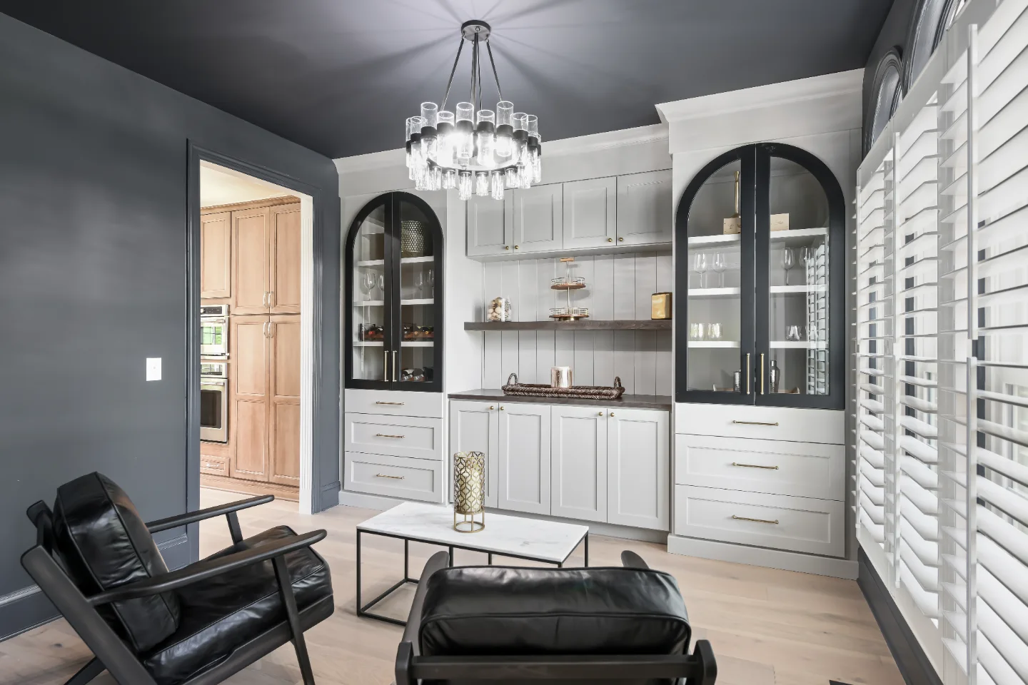 Lounge remodel in Watkins Creek, TN. Sebring Design Build transformed this Watkins Creek dining room in Franklin, Tennessee with Dune and Cinder stain cabinetry accented by Bunker Hill Black, Duchateau The Guild Kayla 7.