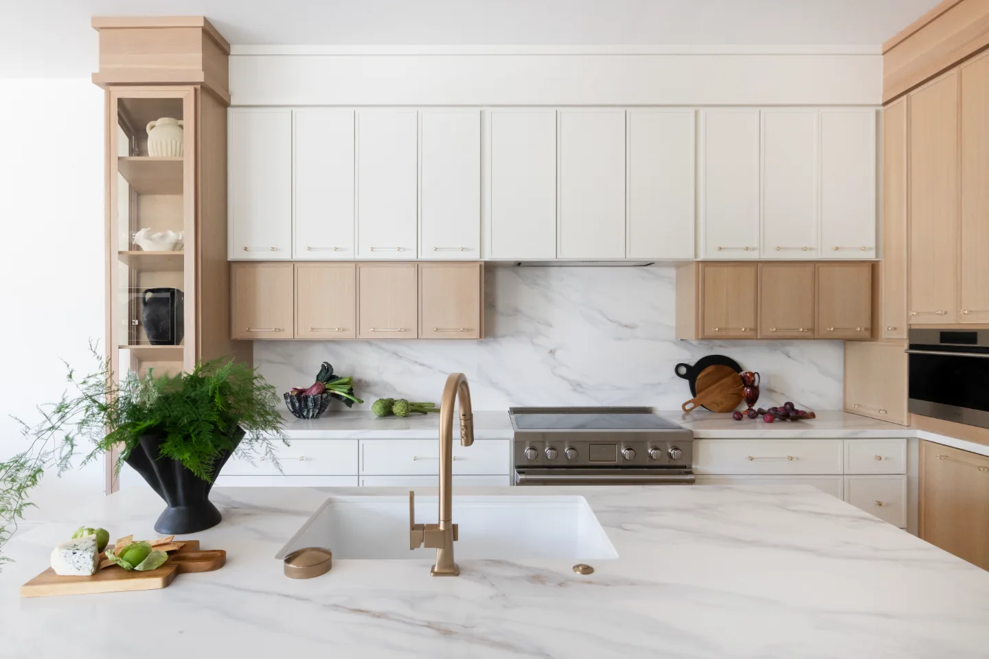 A luxe-minimalist kitchen remodel in Westhaven, Franklin, TN. Rift white oak cabinetry, Calacatta Castana quartz, and Brizo Luxe Gold fixtures by Sebring Design Build.