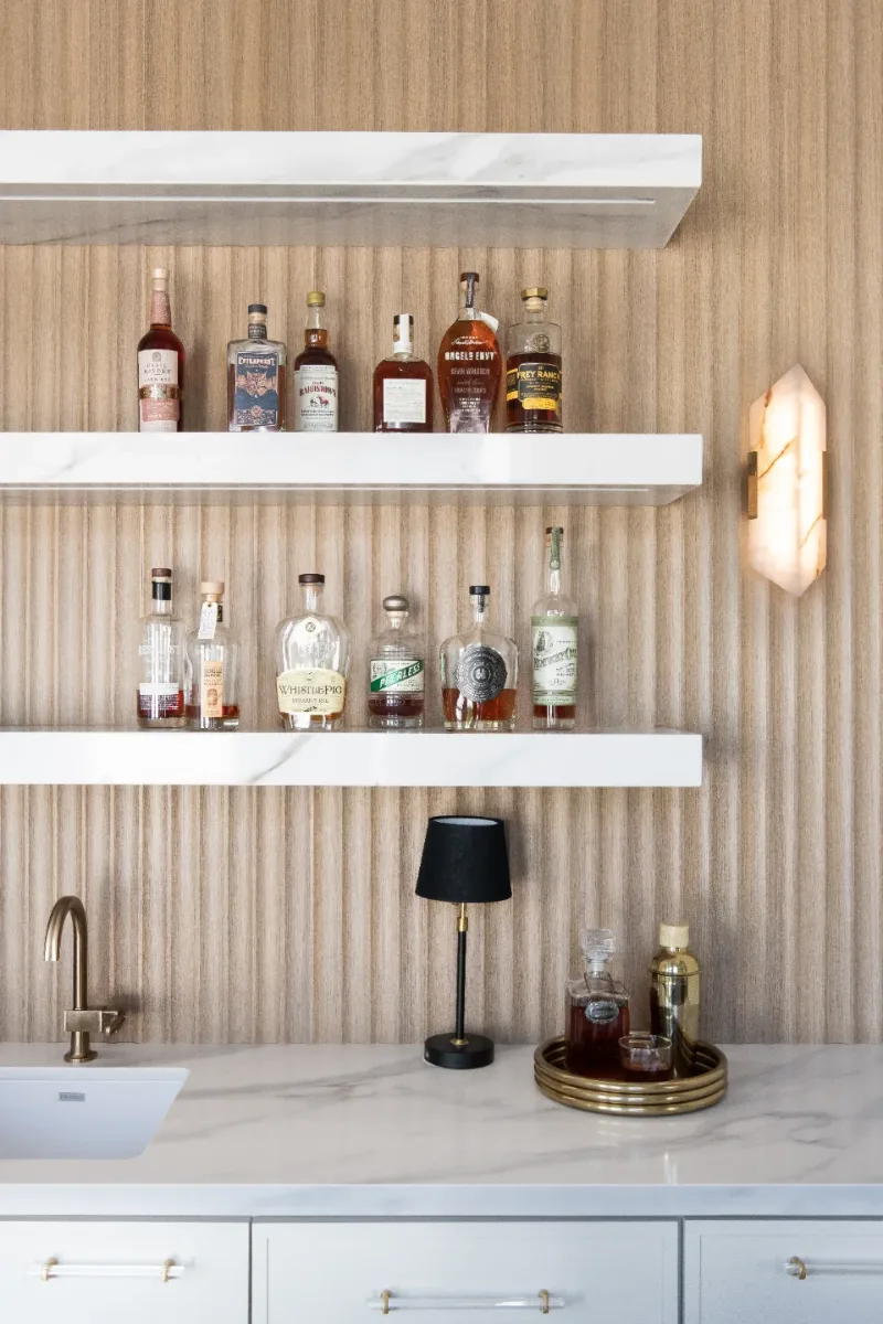 Bar remodel in Westhaven, TN. Sebring Design Build designed this Westhaven bar with MSI Calacatta Castana quartz surfaces, Rift White Oak elements, Brizo Luxe Gold fixtures, and a Franke prep sink.