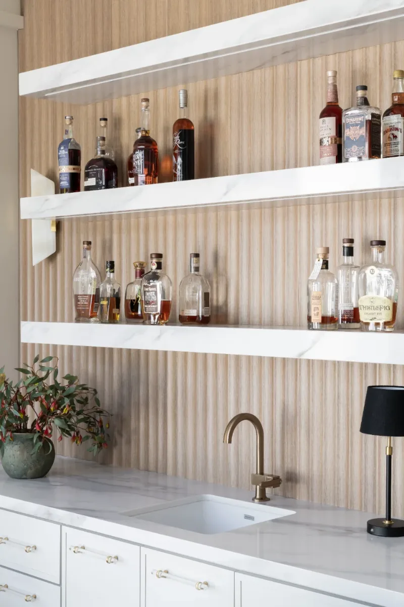 Bar remodel in Westhaven, TN. Sebring Design Build designed this Westhaven bar with MSI Calacatta Castana quartz surfaces, Rift White Oak elements, Brizo Luxe Gold fixtures, and a Franke prep sink.