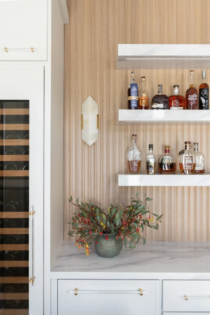 Bar remodel in Westhaven, TN. Sebring Design Build designed this Westhaven bar with MSI Calacatta Castana quartz surfaces, Rift White Oak elements, Brizo Luxe Gold fixtures, and a Franke prep sink.
