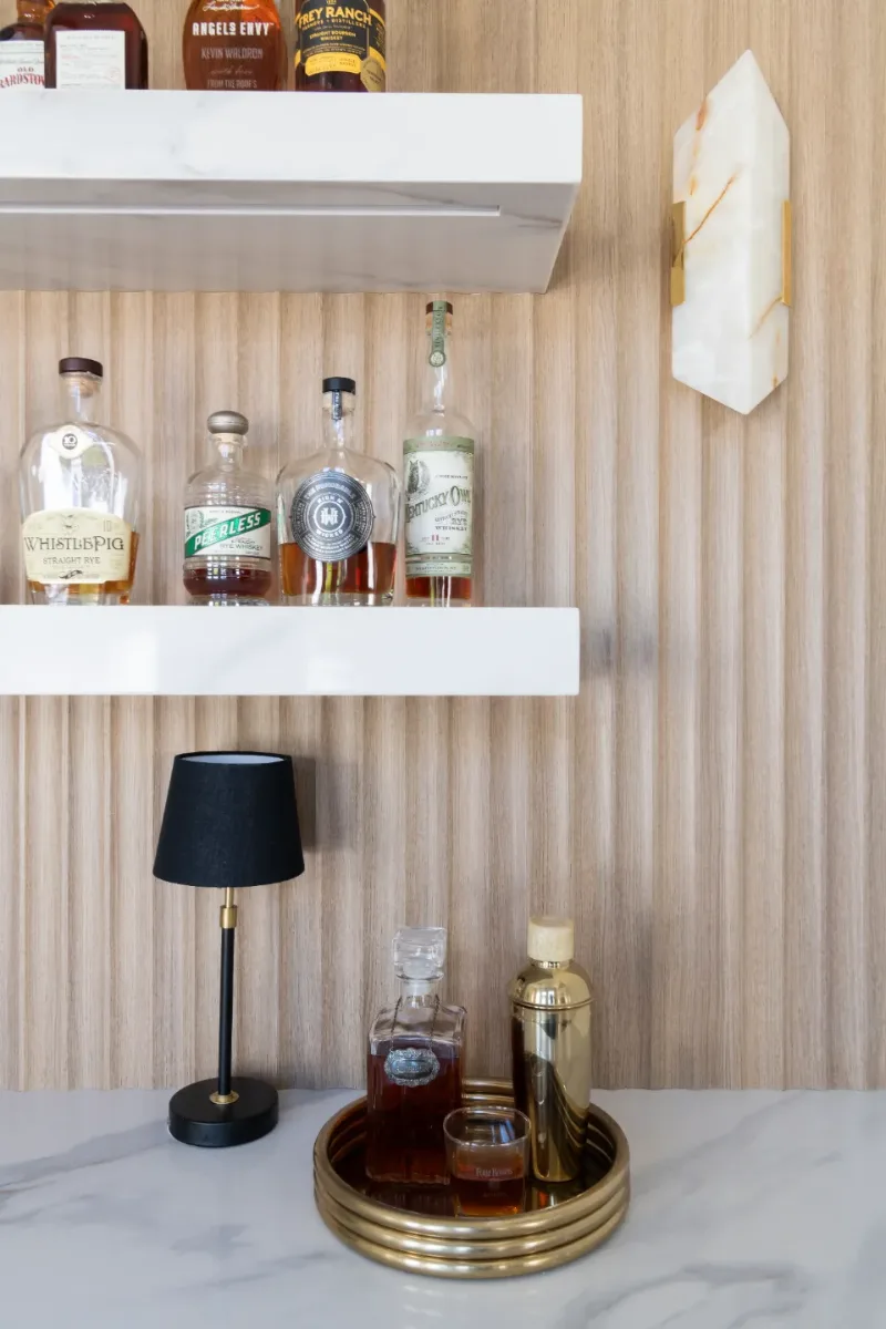 Bar remodel in Westhaven, TN. Sebring Design Build designed this Westhaven bar with MSI Calacatta Castana quartz surfaces, Rift White Oak elements, Brizo Luxe Gold fixtures, and a Franke prep sink.