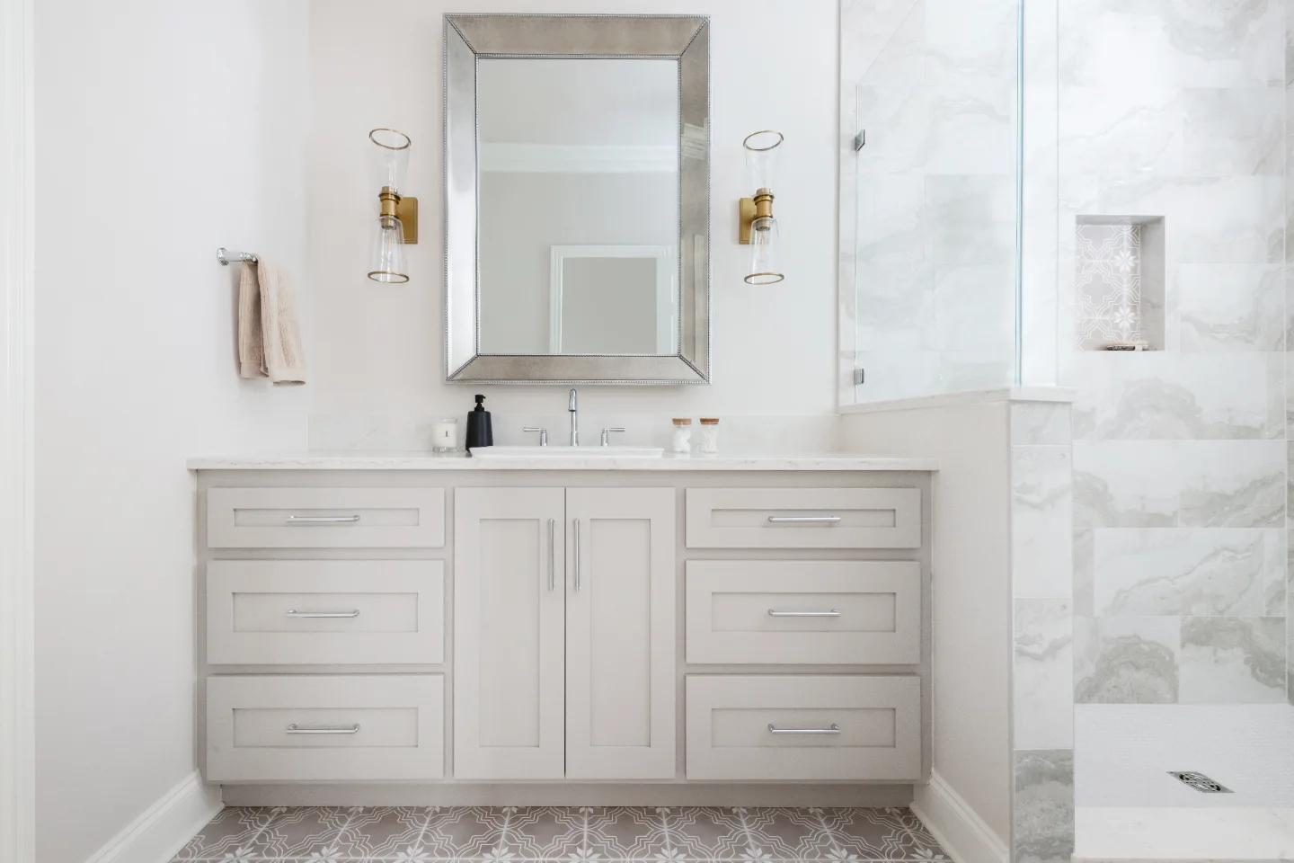 A modern-creamy primary bath remodel in Cool Springs, Franklin TN 37067 with Dune Shaker cabinetry, Metro Quartz Mystique countertops, Delta Chrome fixtures, and gloss light grey porcelain tile by Sebring Design Build.