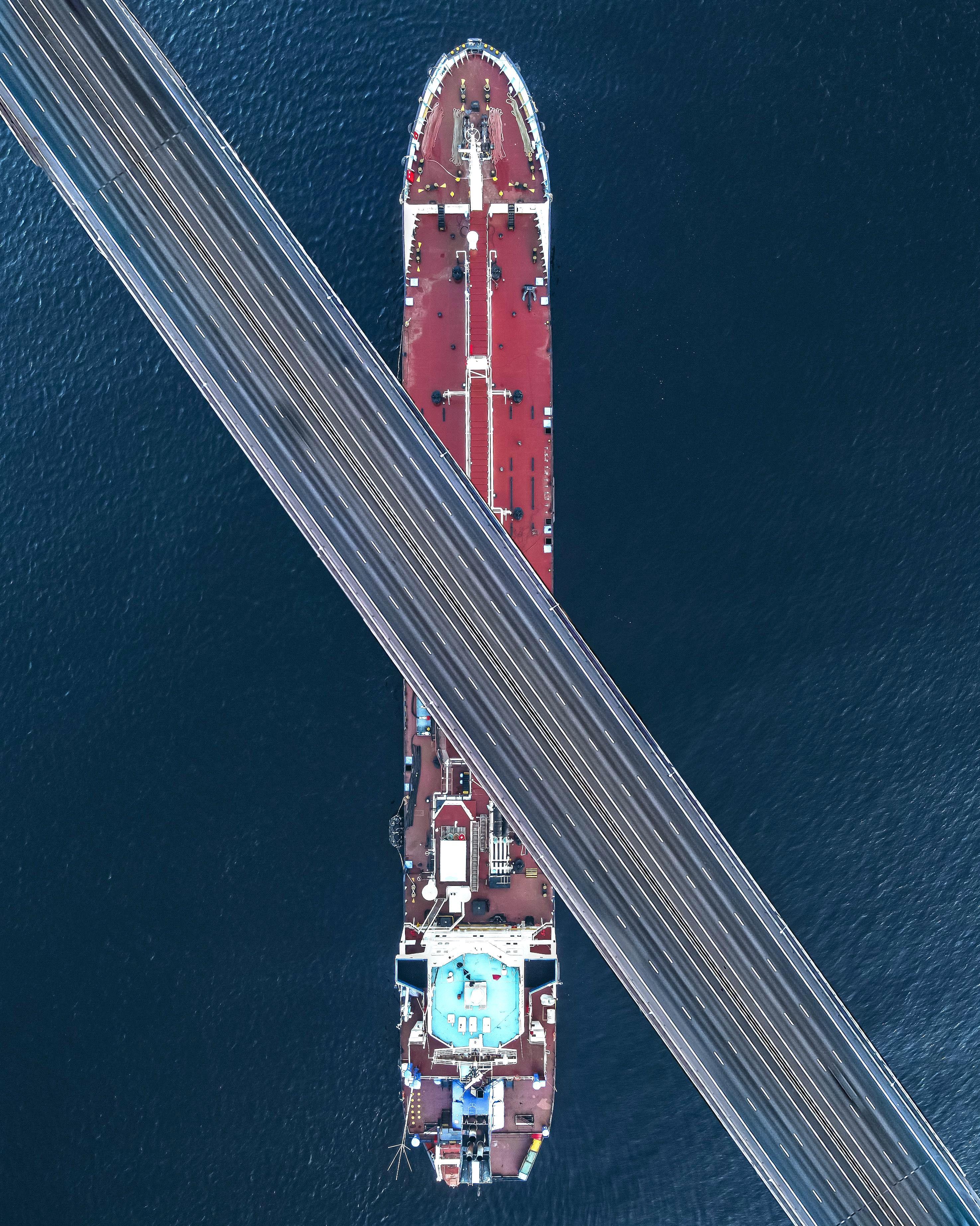 Container ship passing beneath a highway bridge