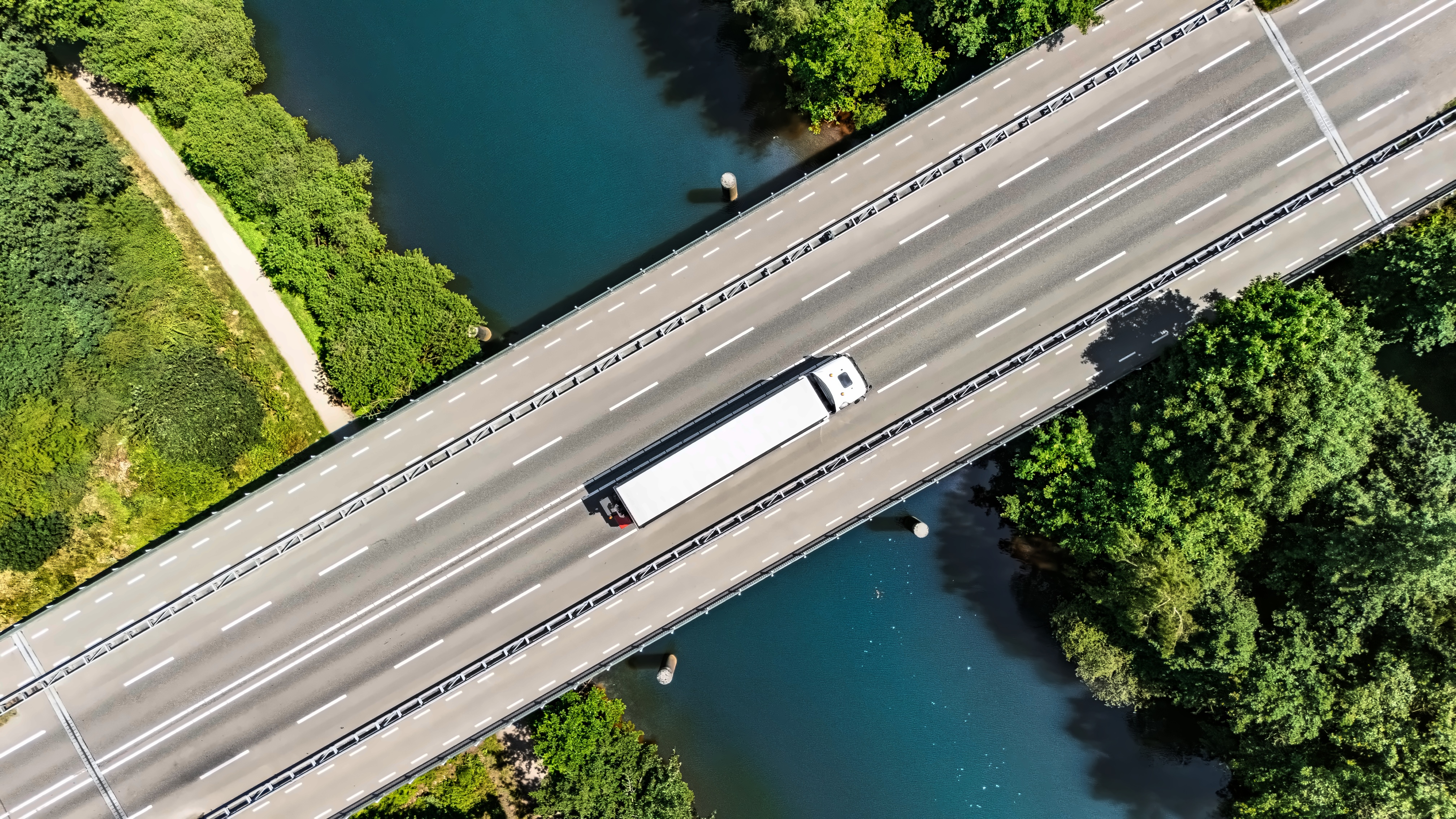 Aerial view of a truck crossing a highway bridge