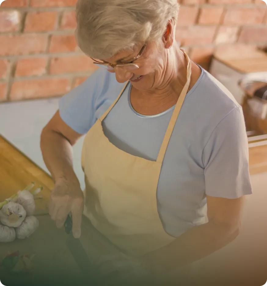 An older woman preparing food in the kitchen