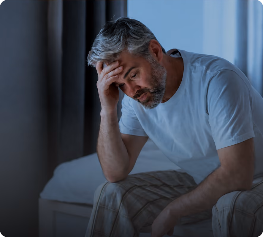 A man lying on a bed, worried
