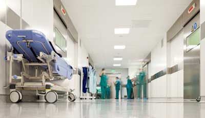 This is an image of doctors in the background of a hospital. It accompanies the blog "Differences between U.S. hospitals and clinics" and outlines how a clinical rotation for IMGs differs in hospitals and clinics.