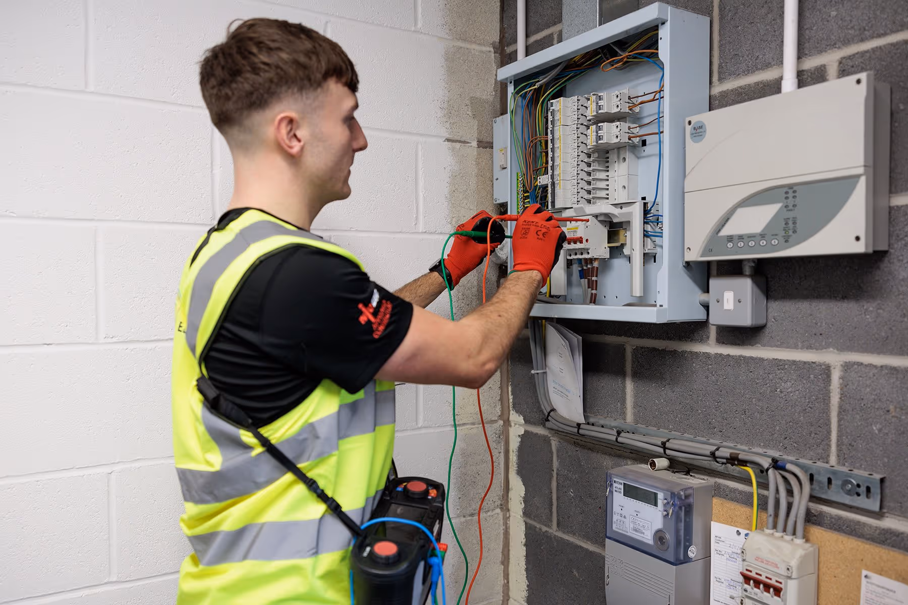 An O'Grady Electrician working on circuit board within an industrial building.