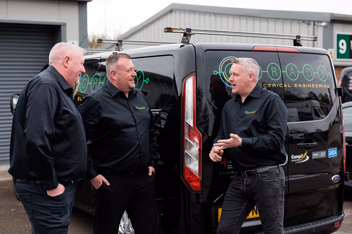 The O'grady management team discussing work in front of one of the company vans.