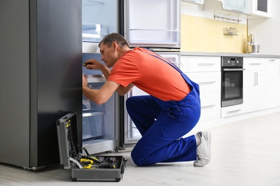 man fixing refrigerator