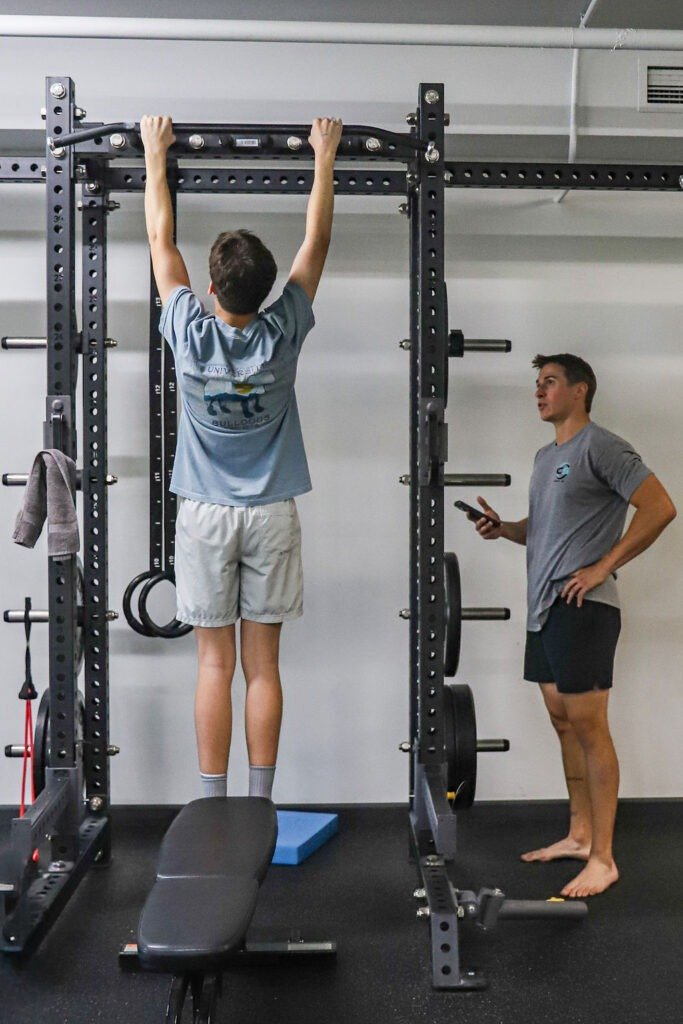 Physical therapist conducting movement assessment with athlete