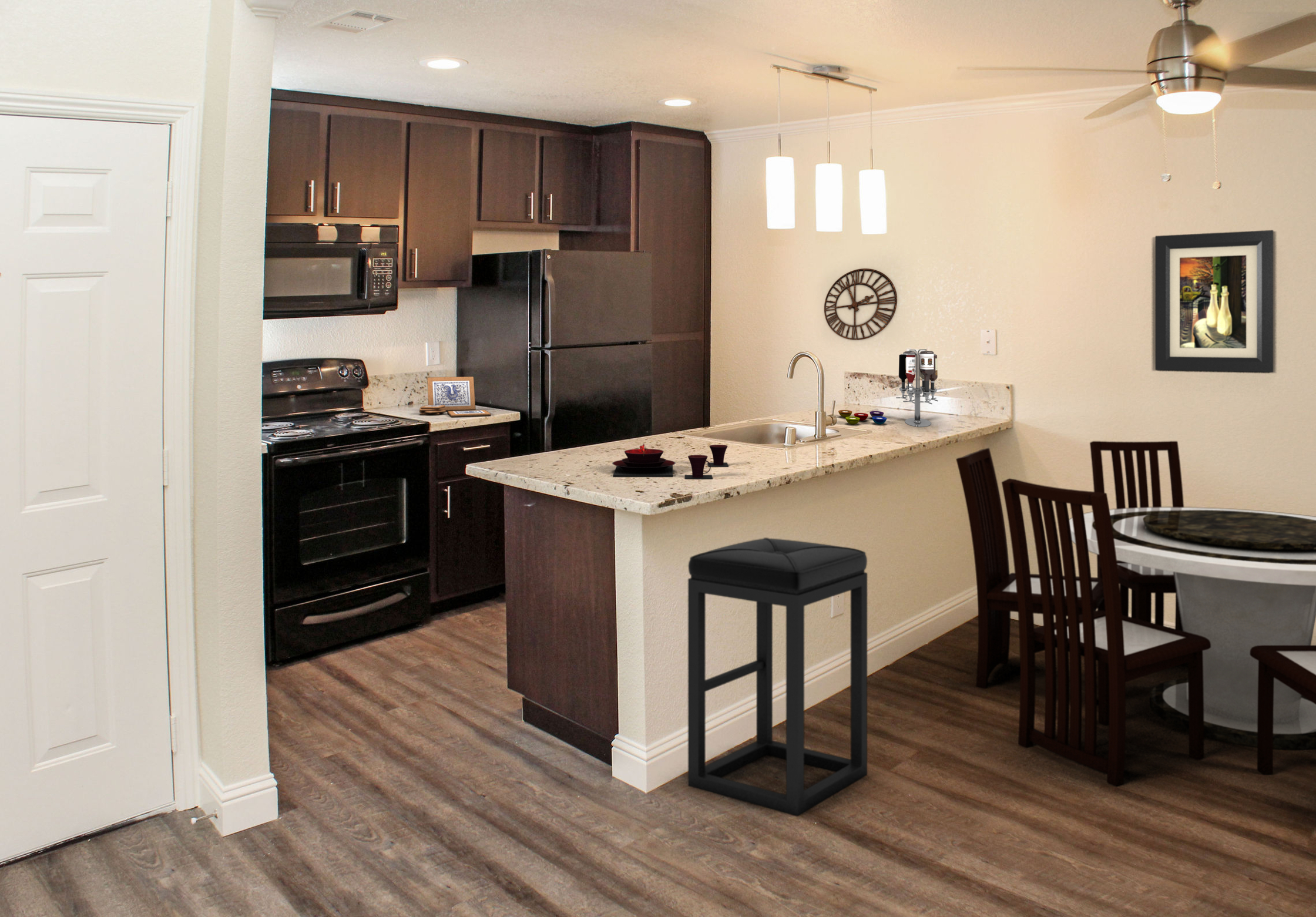 Kitchen with brown cabinets and black appliances with breakfast bar