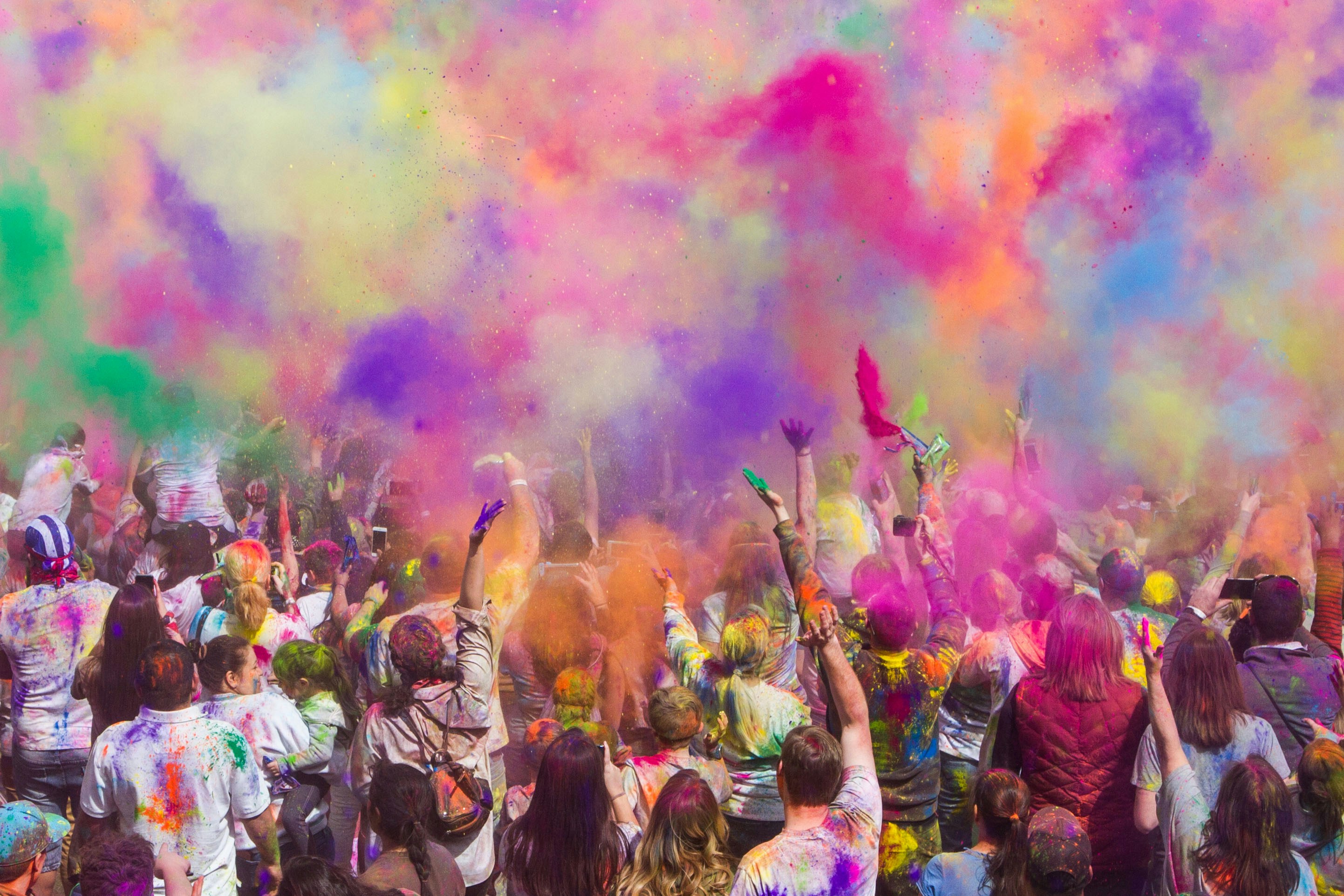 Feiernde Menschenmenge mit bunten Farbwolken bei einem Open-Air-Festival