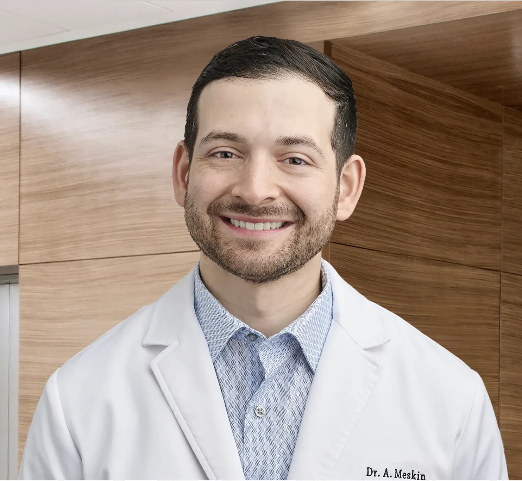 Professional headshot of Dr. Alan Meskin in white coat and blue shirt