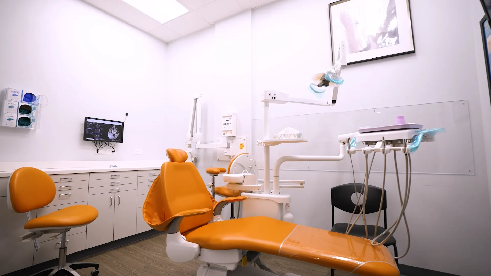 Dental treatment room with orange dental chair