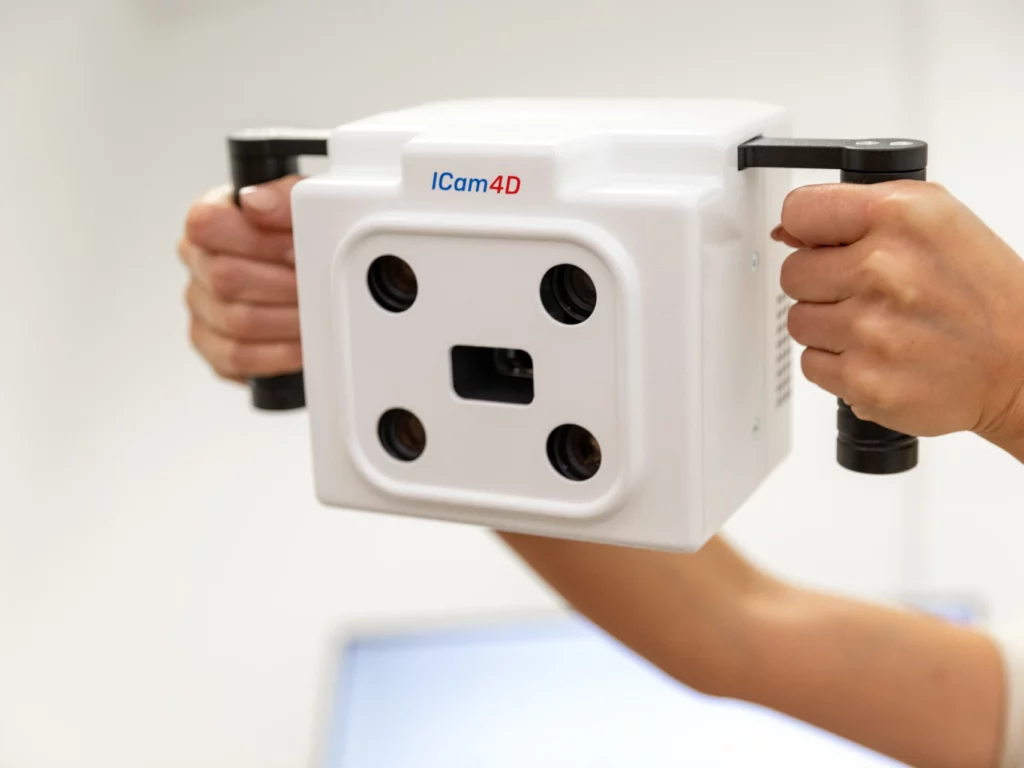 Hands holding a white digital scanning device or measurement tool