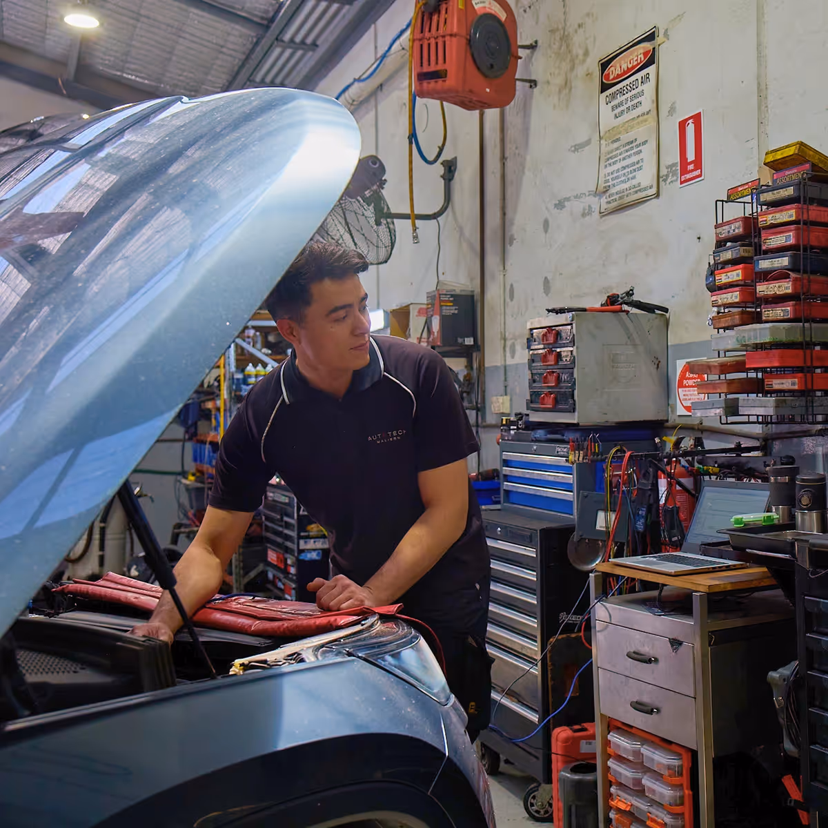 Technician inspecting a vehicle air-conditioning system in the workshop.