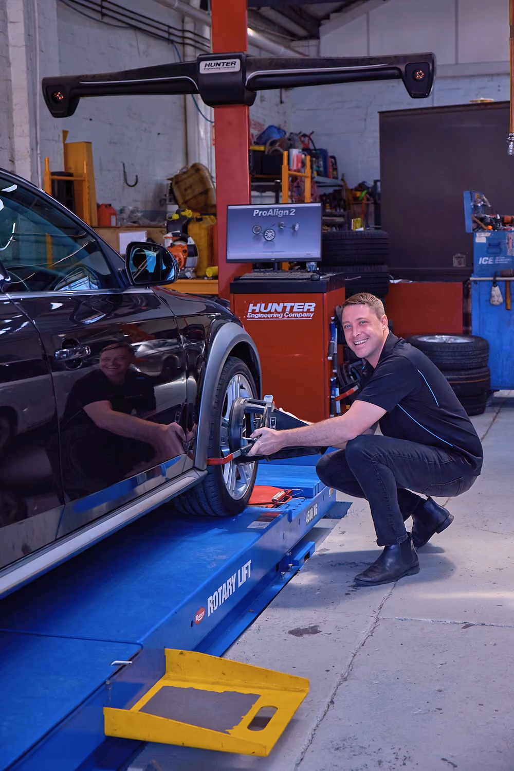 Technician performing an inspection on a car in a workshop.