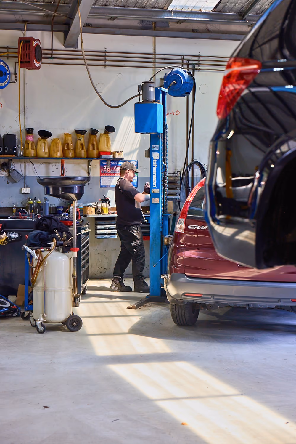 Mechanic servicing vehicles in a professional automotive workshop.