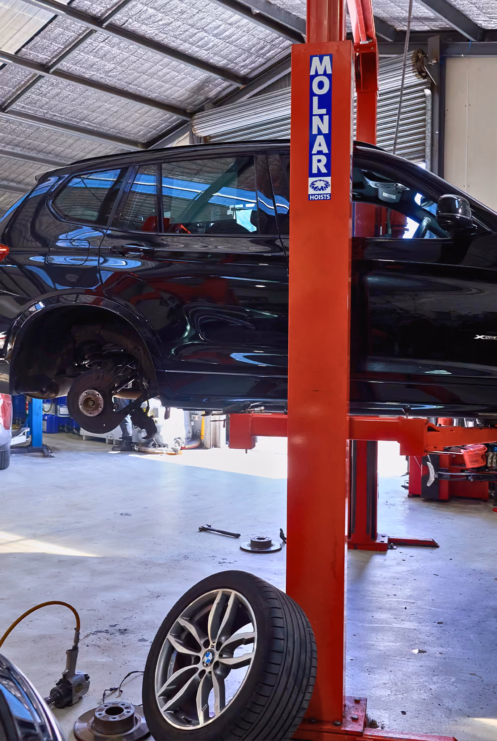 Car lifted for safety inspection service in Melbourne workshop.