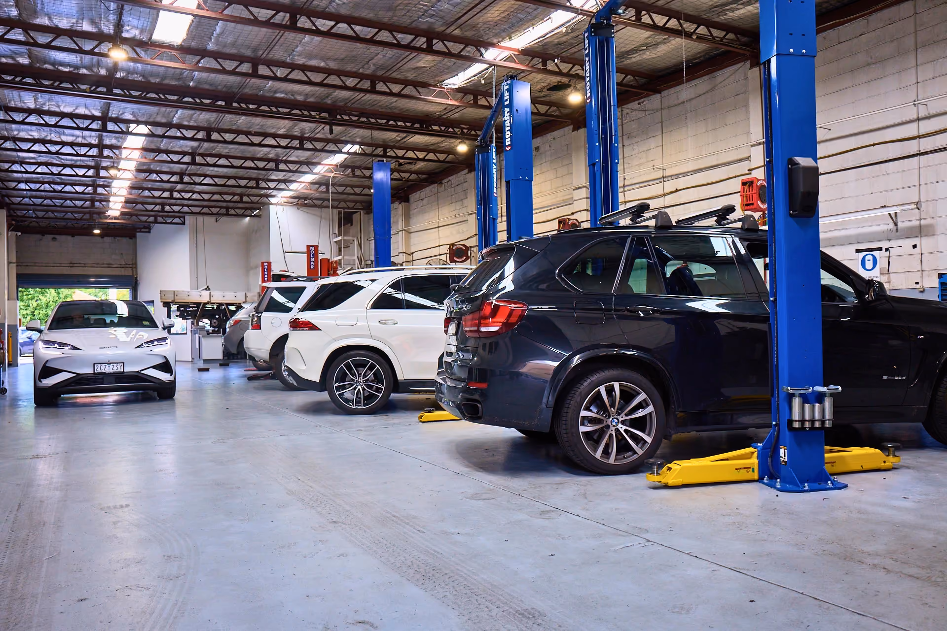 Modern vehicles being serviced in a professional independent automotive workshop.