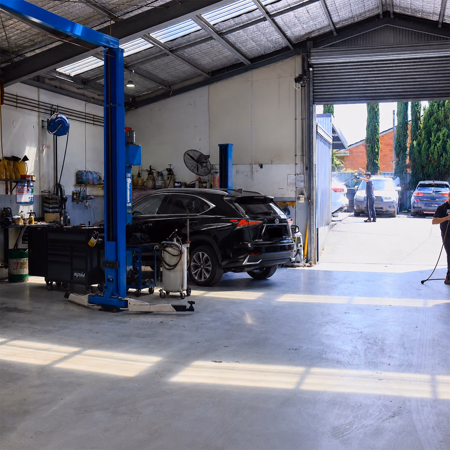 White and grey Lexus SUVs parked inside a modern automotive workshop awaiting servicing and inspection.