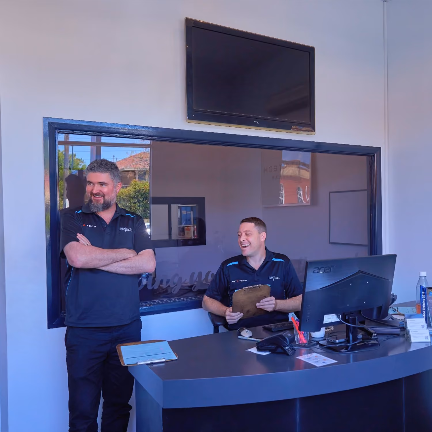 Auto Tech Group team assisting customers at reception desk.