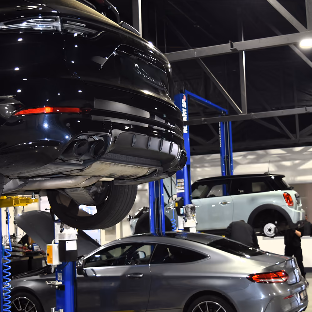 European vehicles on hoists in the Auto Tech Group workshop.