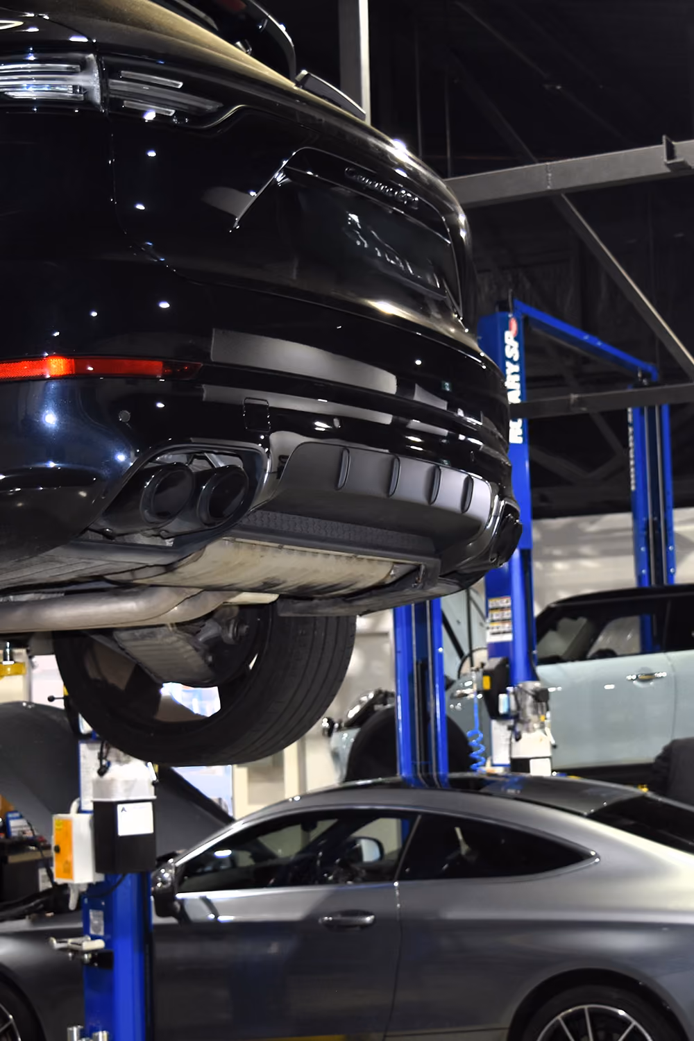 European vehicles raised on hoists inside the workshop.