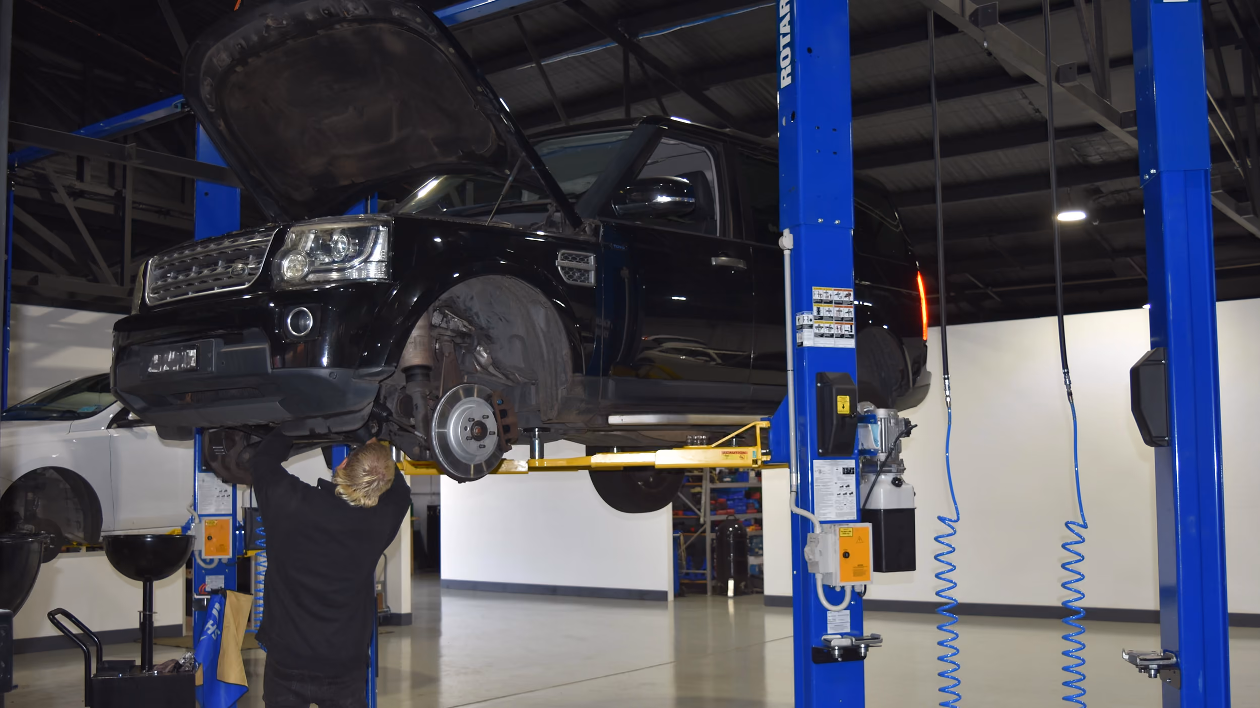Range Rover raised on a workshop hoist during brake service.