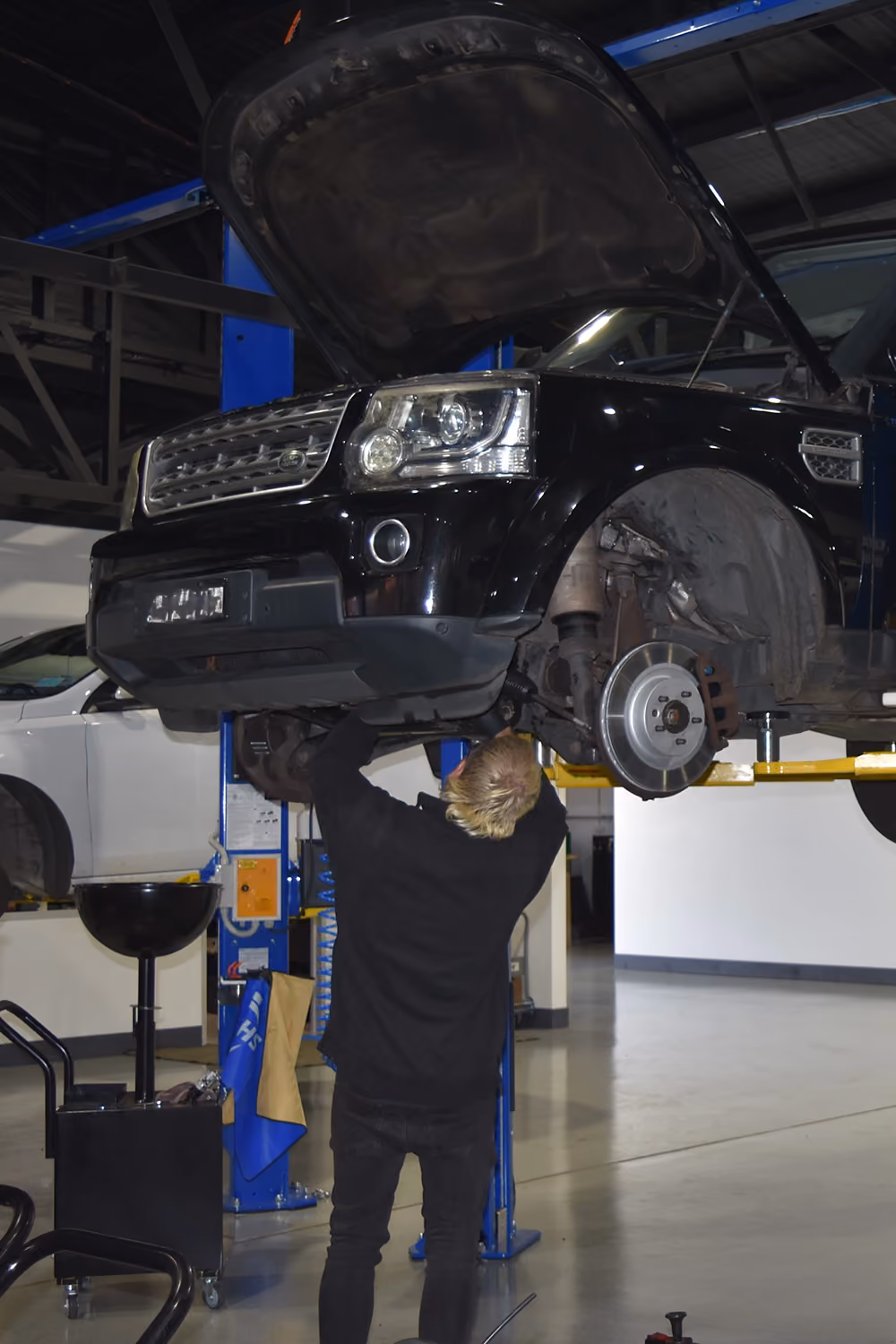 Range Rover raised on a workshop hoist during brake service.