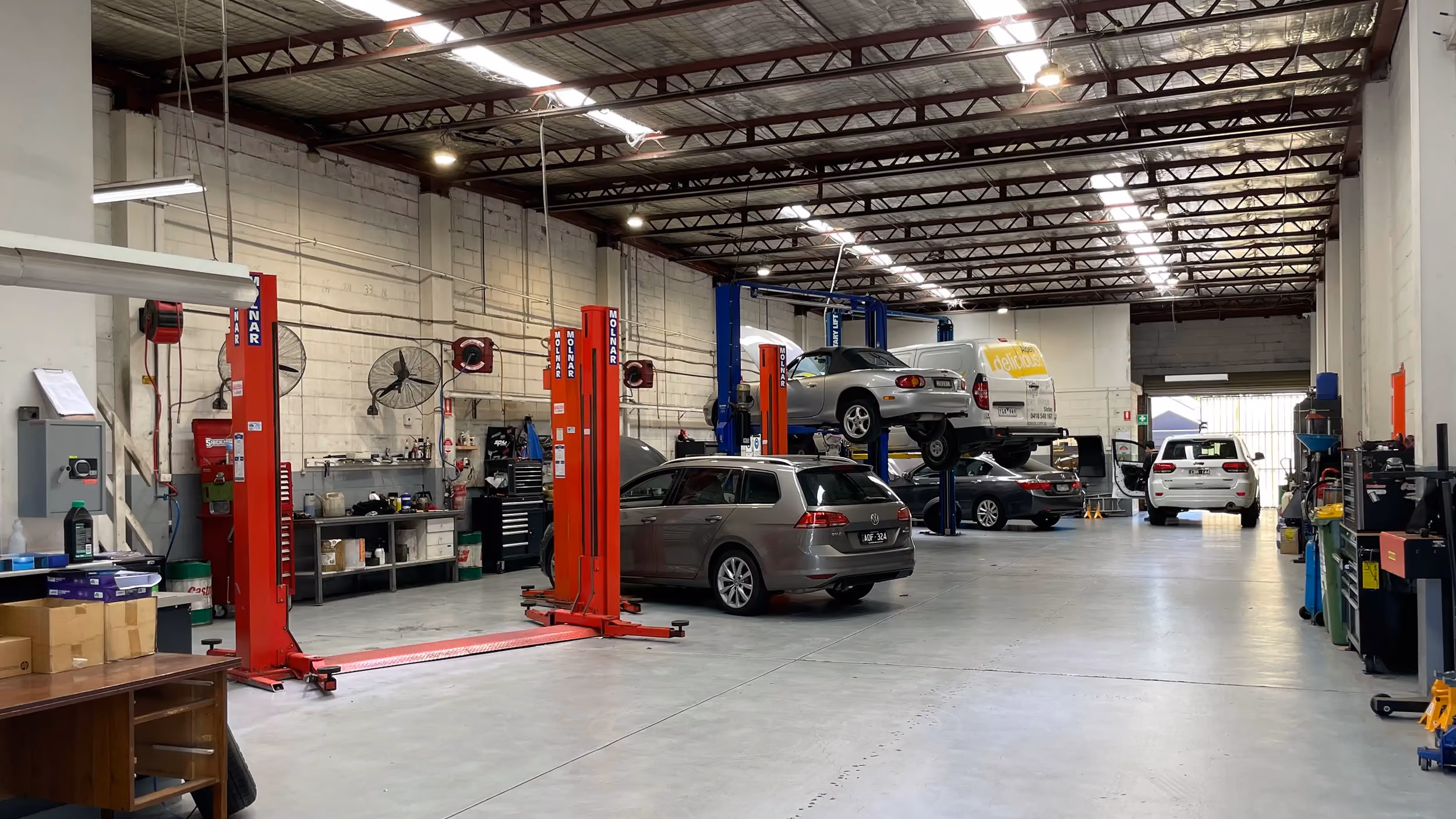 Malvern East workshop interior with multiple vehicle brands in the bays.