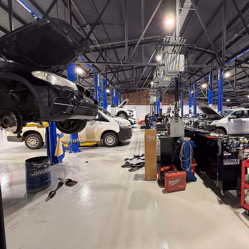 Wide interior view of the Weir Street workshop with vehicles in service bays.