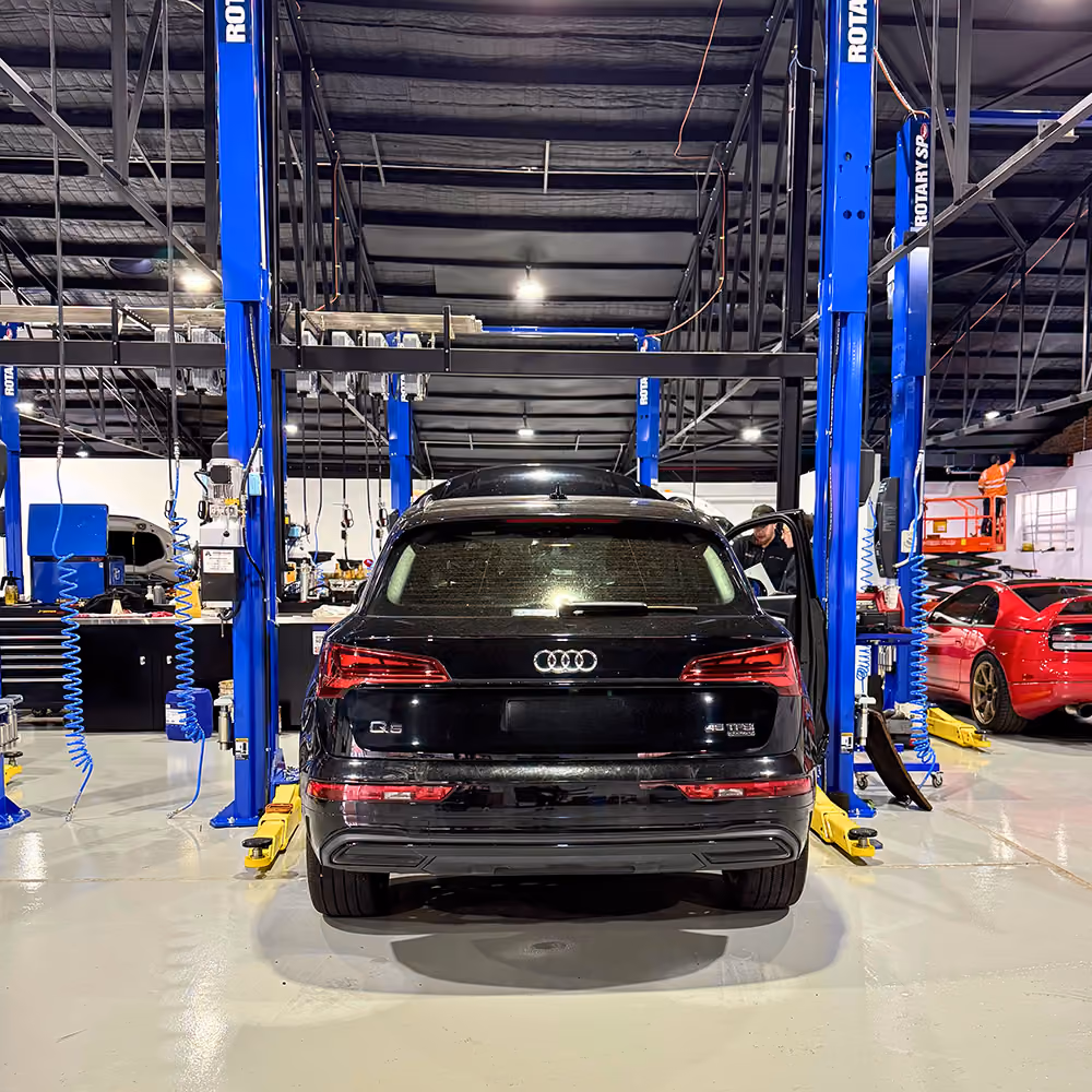 Audi inside the Auto Tech Group workshop with service bays in the background.