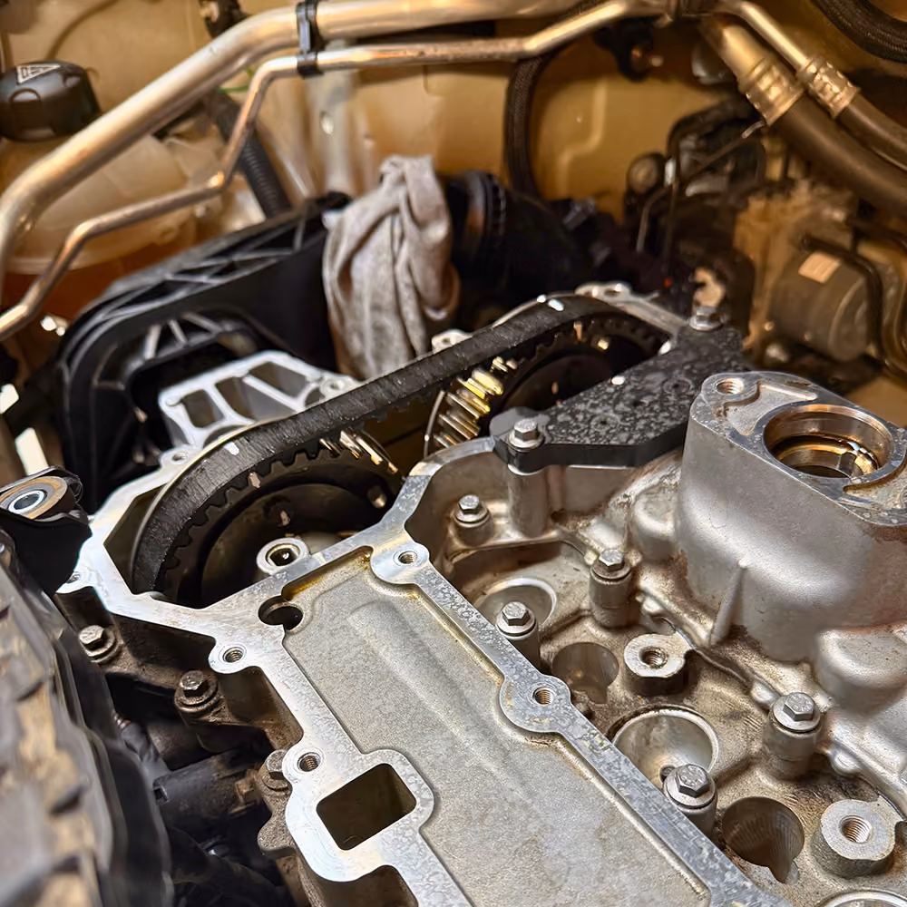 Timing belt and camshaft sprockets in an engine bay during timing belt replacement.